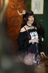 Naklejka premium Portrait of asian girl in lolita fashion dress in vintage garden background