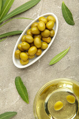 Olive oil with olive on grey background. Vertical photo