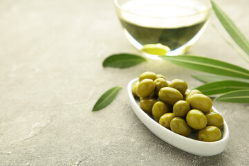 Olive oil with olive on grey background with copy space.