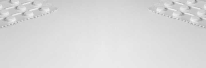 White medical background with sachets of tablets on the sides of the image