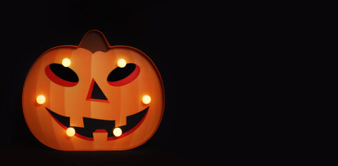 Spooky Halloween pumpkin Jack O Lantern with glowing lamps on a black background. ?opy space for text.