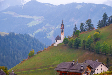 Church of Santa Barbara in the cozy little village of La Valle on a foggy morning, Alta Badia, South Tyrol