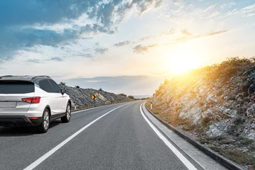 Fotobehang Goud Geel White car on a scenic road. Car on the road surrounded by a magnificent natural landscape.  © Denis Rozhnovsky