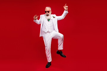 Fototapeta na wymiar Full body photo of funky old cheerful man dance wear three piece suit enjoy isolated on red color background