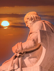 Plato, the ancient Greek philosopher in deep thought statue during sundown, Athens Greece.