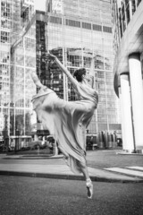 Ballerina, ballet dancer on modern city background. Attitude position. Grainy black ad white photo.