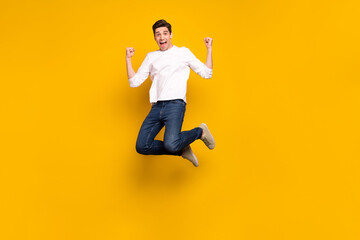 Fototapeta na wymiar Full length body size photo man gesturing like winner jumping up isolated vivid yellow color background