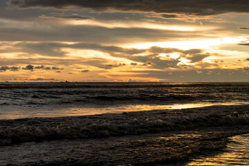 Fototapeta na wymiar Dramatic golden sunset hour over the sea