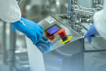 Closeup shot of medics working on a complex metallic machine with buttons and display