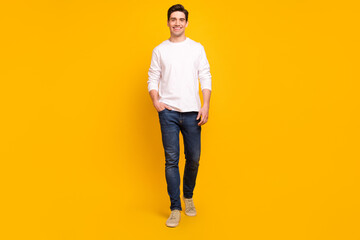 Fototapeta premium Full length body size photo brunet guy in casual outfit smiling confident walking forward isolated vibrant yellow color background