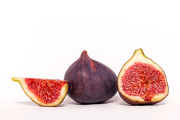 Ripe figs and half a fruit on a green leaf background. Fresh fruit. White background.