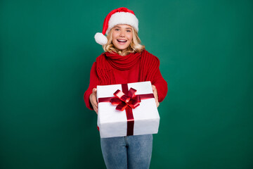 Photo of young girl happy positive smile guest hold gift box party santa hat isolated over green color background