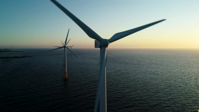 Beautiful sunset background the wind power generators on the sea, Offshore wind turbine in Jeju Island. South Korea. 제주 해안 풍력발전