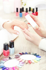 Obraz na płótnie Canvas Manicurist making manicure for client by nail file
