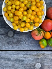 Multi-colored ripe tomatoes on a wooden background. Background. Vegetarian concept. Place for your text.