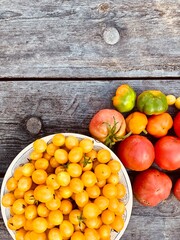 Multi-colored ripe tomatoes on a wooden background. Background. Vegetarian concept. Place for your text.