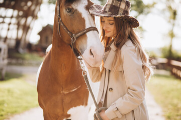 Young happy woman with horse at ranch