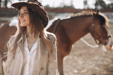 Young happy woman with horse at ranch