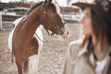 Young happy woman with horse at ranch