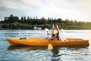 Beautiful young woman kayaking in river. Summer activity