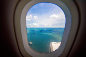 beautiful view from window of plane to sea and ships. carefree view from porthole landing airplane