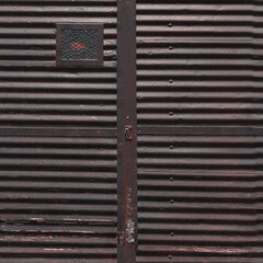 An old corrugated metal door of a cargo elevator or container with traces of rust and corrosion. 3D-rendering.