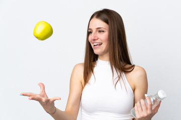 Young caucasian woman isolated on white background with an apple and with a bottle of water