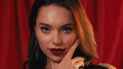 gorgeous young woman with bright lipstick looking at camera on red.