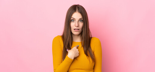 Young caucasian woman isolated on pink background pointing to oneself