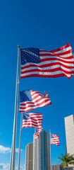 Waving american flags against modern buildings and blue sky