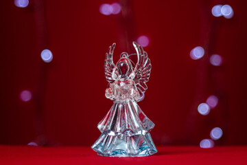 Glass figurine of an angel on a festive background. The concept of Christmas and religious holiday