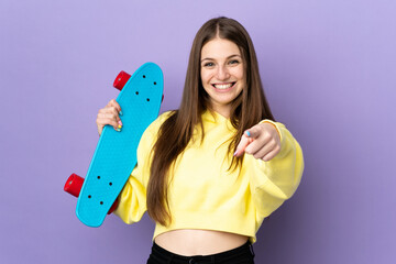 Young caucasian woman isolated on purple background with a skate and pointing to the front