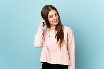 Young caucasian woman isolated on blue background having doubts