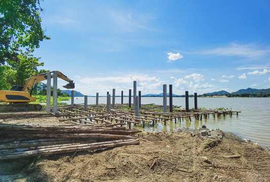 The construction of a small jetty for the convenience of boarding and landing jet skis along the river. Build a berth that juts out into the river with beams made of logs and cement columns.