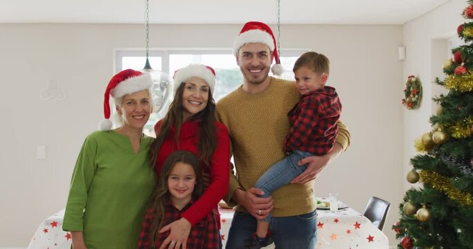 Happy Caucasian Multi Generation Family Wearing Santa Hats And Looking At Camera