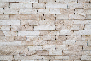 The background of the wall is made of strips of natural cream marble with a beautiful pattern of cream-colored stone. Backgrounds texture design.