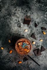 delicious chocolate ice cream with nuts in jar on dark background, vertical image. top view. place for text