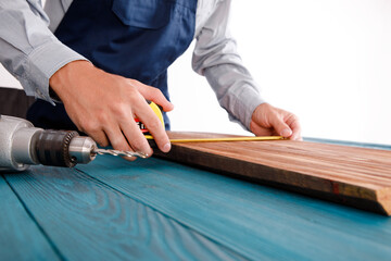 Handyman in blue uniform works with electricity automatic screwdriver. House renovation conception.