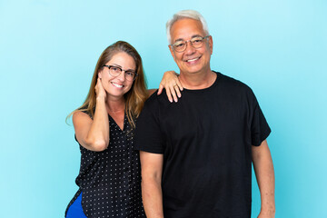 Middle age couple isolated on blue background happy and laughing