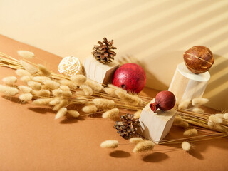 Original hand-made composition on a beige background - cereals, pine cones, fruits and geometric shapes. Abstraction. Interior decor. Halloween, Thanksgiving, Christmas, harvest festival.