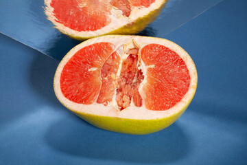 sliced mirrored yellow grapefruit on blue background