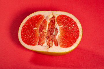 sliced yellow grapefruit on red background