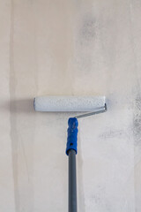 Primed with a roller with a primer putty wall before painting or gluing wallpaper