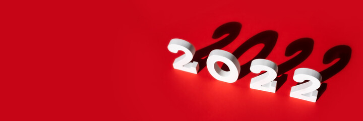 New year 2022. White number 2022 with shadow isolated on red background Christmas greeting card. Invitation template. Top view, flat lay, copy space. Banner