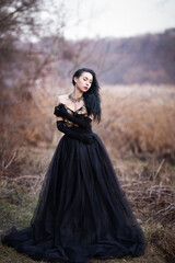 brunette in black dress in the woods