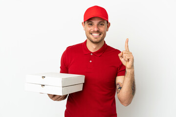 pizza delivery man with work uniform picking up pizza boxes over isolated  white wall showing and...
