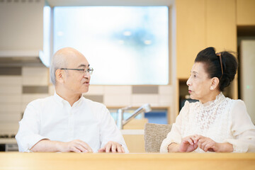 Obraz premium リビングルームで仲良く談笑するシニア夫婦