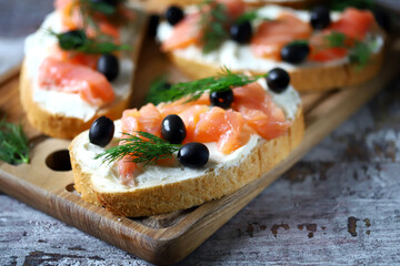 Sandwiches with salmon, cream cheese and olives. Healthy food.