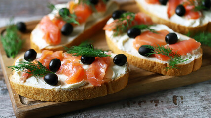 Sandwiches with salmon, cream cheese and olives. Healthy food.