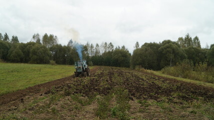 tractor ploughs arable land, an agricultural concept